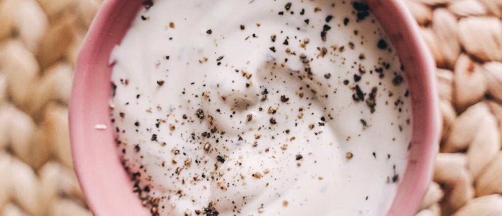 Bol de yaourt crémeux saupoudré de poivre pour dégustation