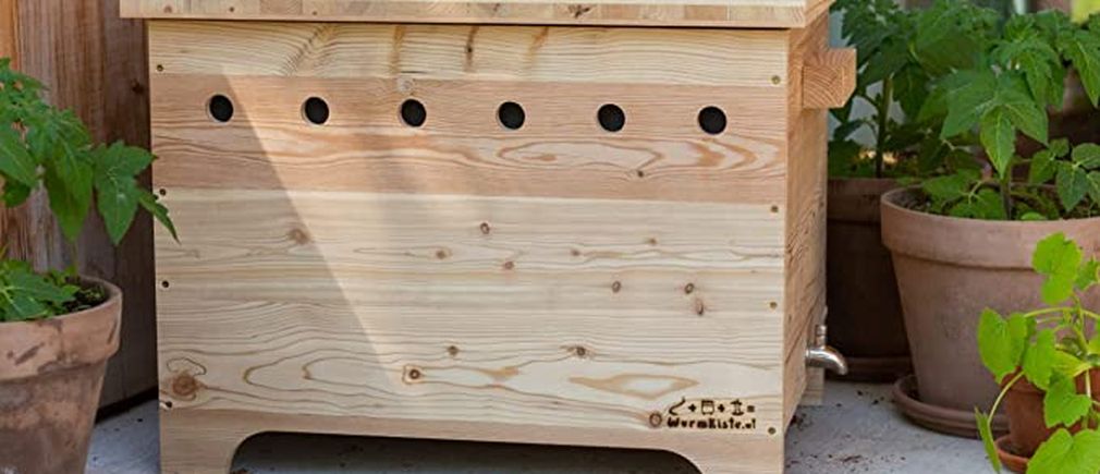 Composteur en bois posé sur balcon avec plantes en pots