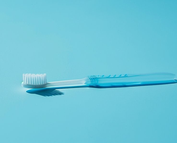Brosse à dents en plastique posée sur un fond bleu