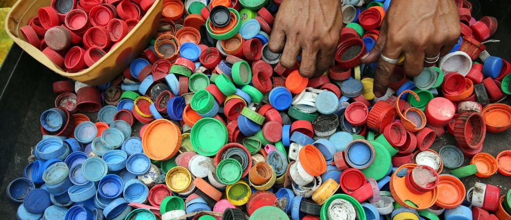 Mains triant des bouchons plastiques multicolores