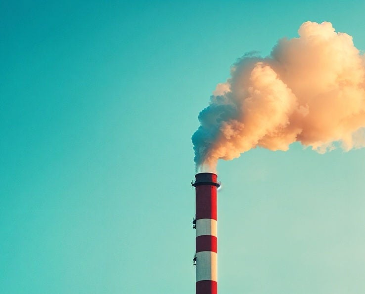 Cheminée industrielle émettant un nuage de fumée