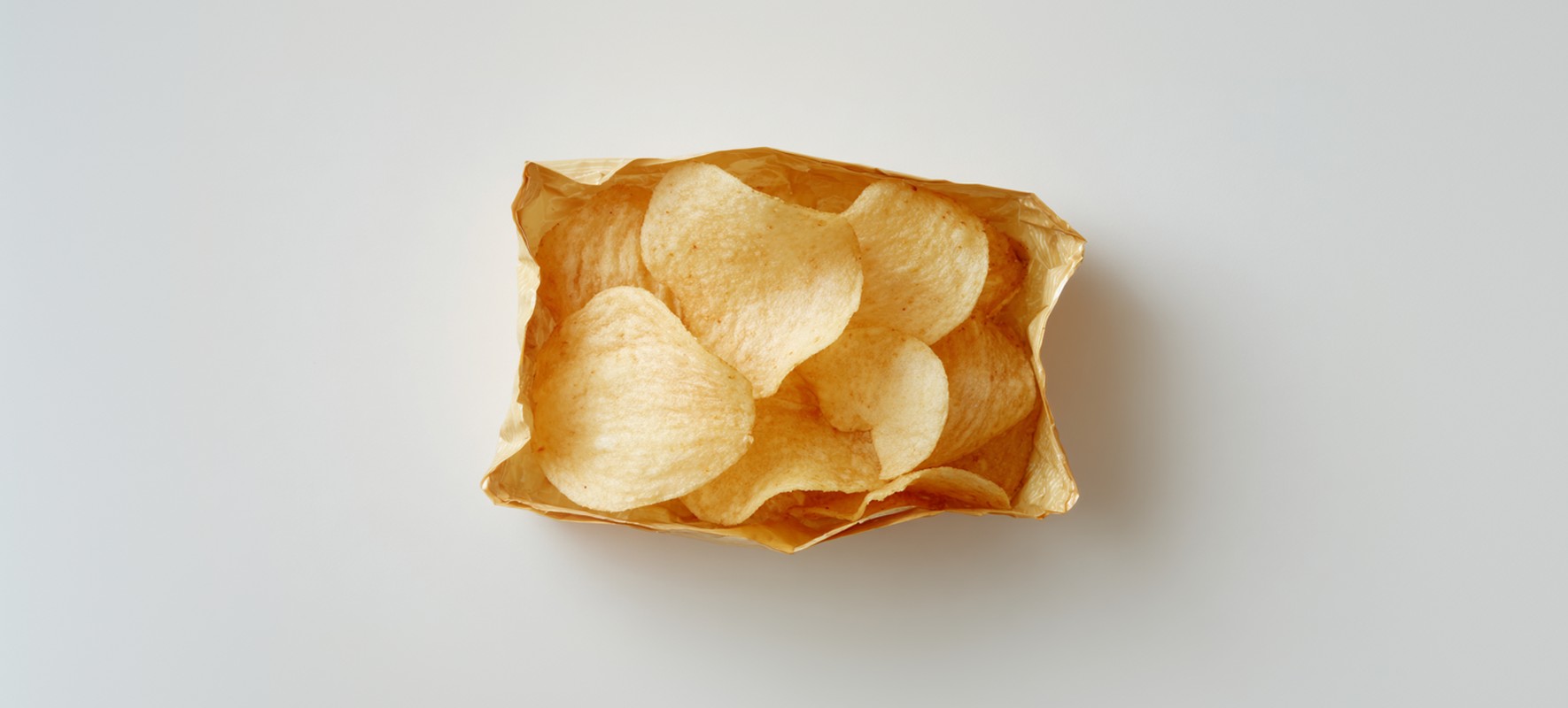 Una bolsa de patatas fritas naturales está abierta y vista desde arriba